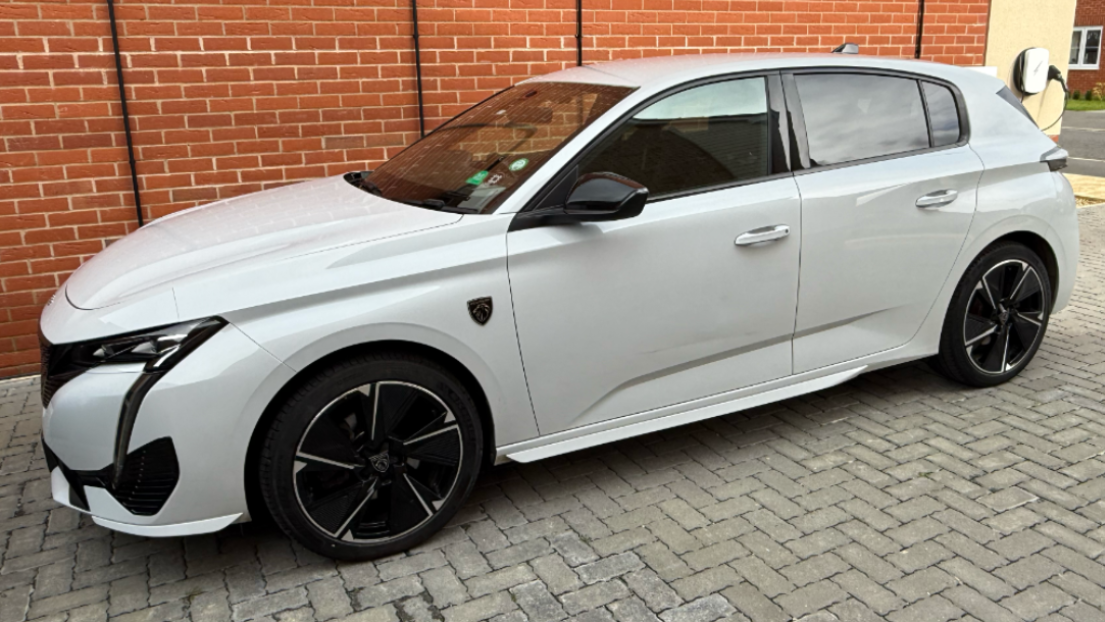 Our white Peugeot e-308 GT electric car parked outside